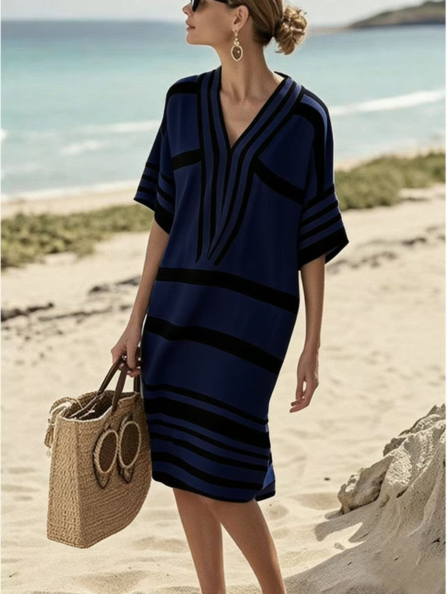Blue striped midi dress with V-neck and half sleeves, styled with a straw bag.