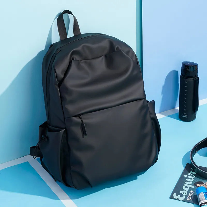 Black canvas laptop backpack with zippered front pocket and side water bottle holders.
