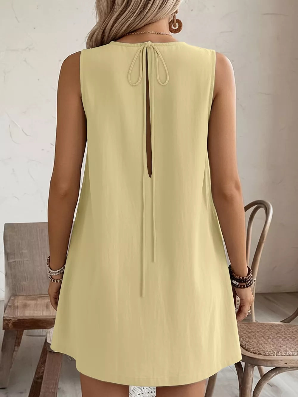 Pastel yellow sleeveless dress with back tie and frill detail