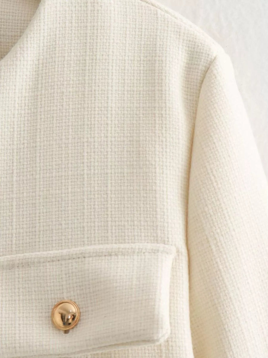 White tweed cropped jacket with gold button detail and pocket.
