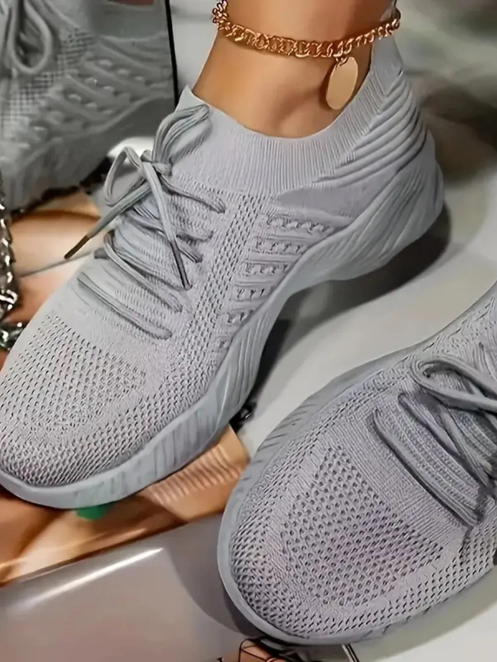 Gray knit runner sneakers with sculpted sole and lace-up closure.