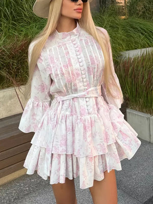 White floral print dress with tiered ruffles, high neck, button front, and bell sleeves.