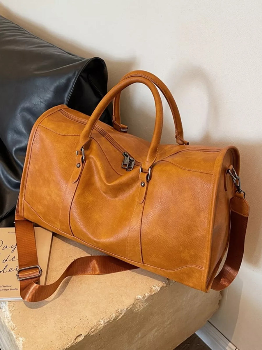 Cognac vintage leather duffle bag with top handles and adjustable strap.