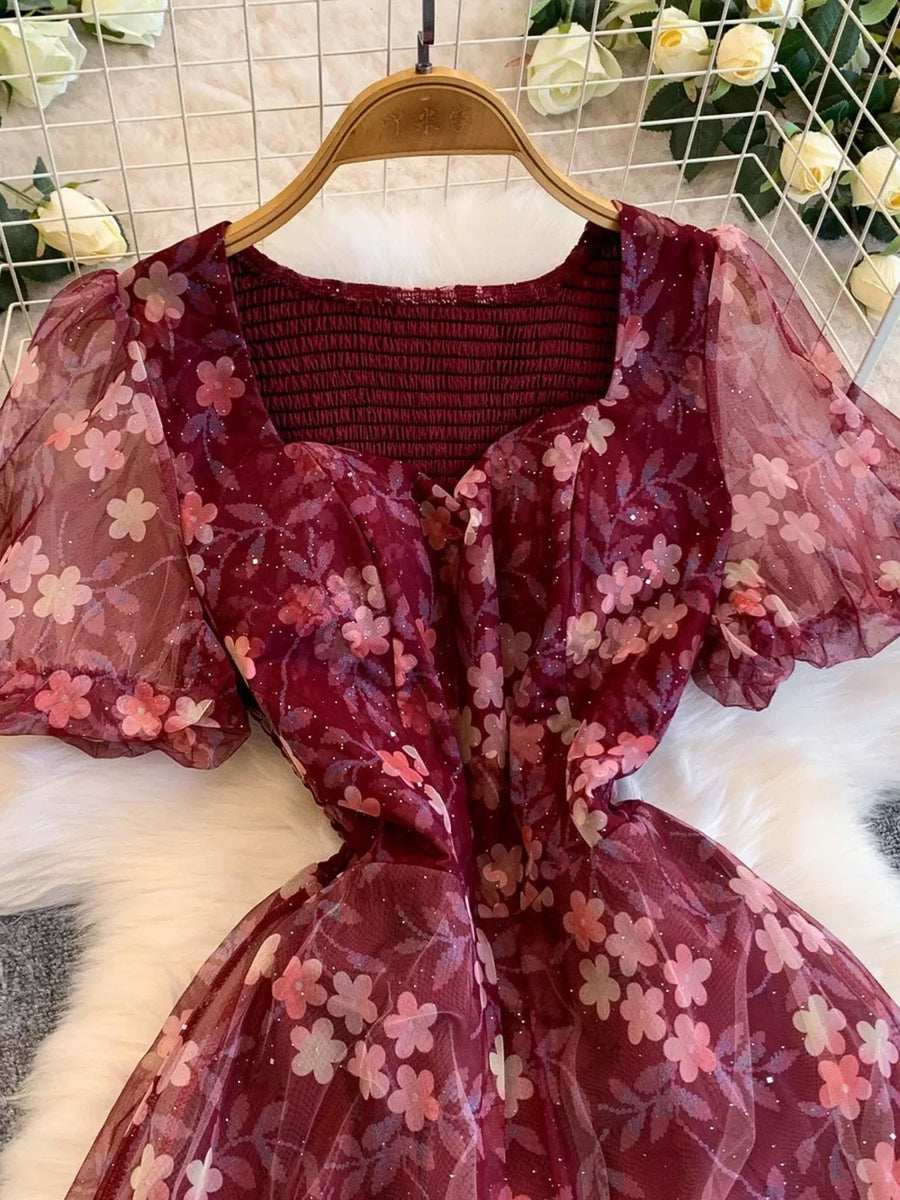 Crimson floral print maxi dress with sweetheart neckline and sheer puff sleeves.