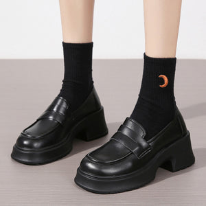 Black leather round toe block heel loafers with chunky sole and strap detail.