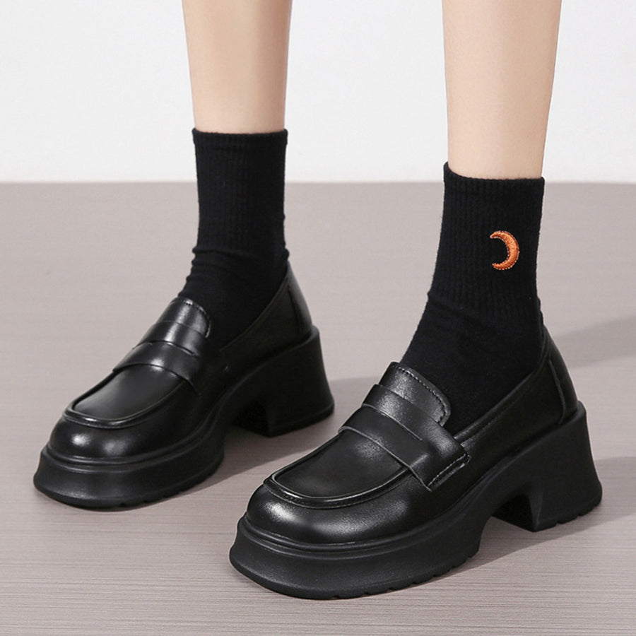 Black leather round toe block heel loafers with chunky sole and strap detail.