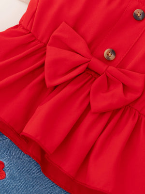 Red bowknot top with button detail and denim shorts with heart embroidery.