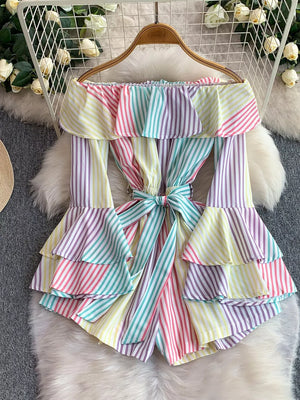 Playful off-shoulder romper in color strips with ruffled tiers and a belted bow.
