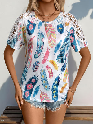 White feather print blouse with crochet short sleeves and a scoop neck.