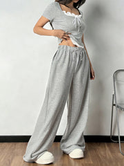 Grey tie front cropped top with white trim and drawstring wide-leg pants set.