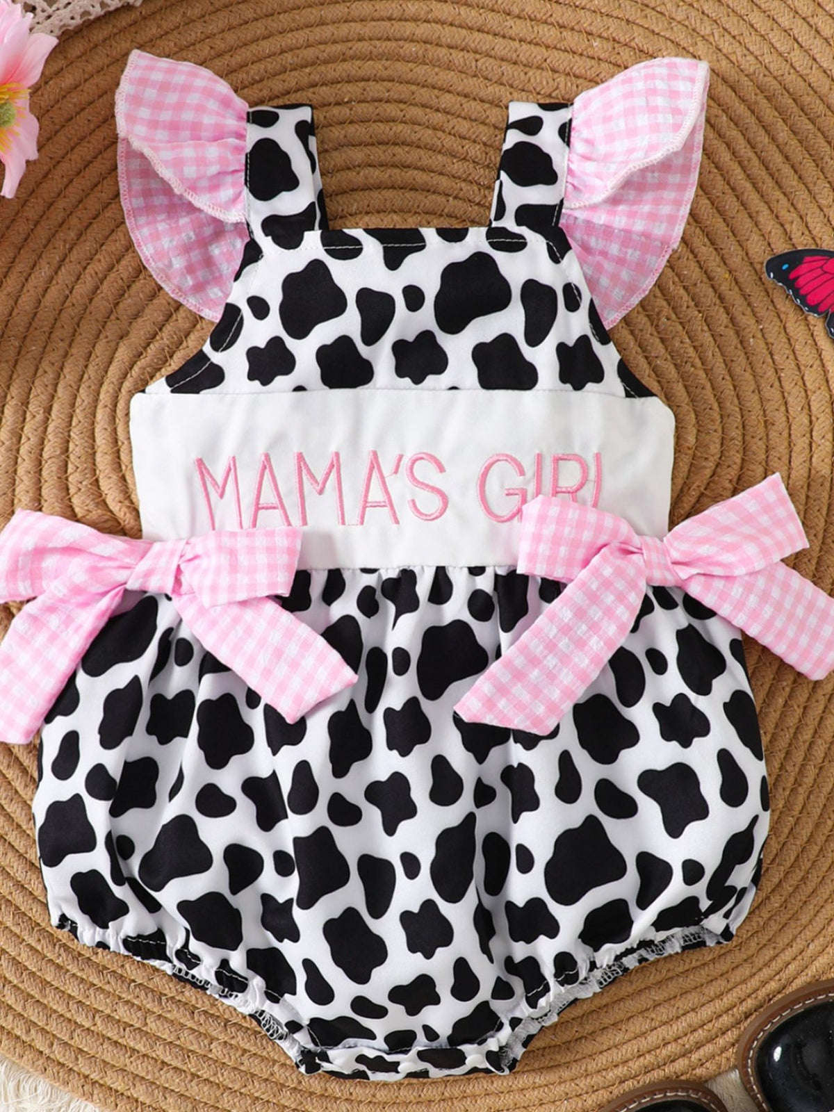 Baby one-piece with cow print, pink gingham ruffles, bows, and "Mama's Girl" embroidery.