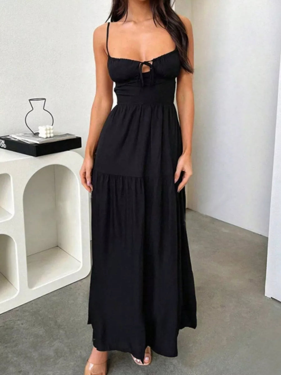 Black maxi dress with spaghetti straps, tie-front bodice, and tiered skirt.