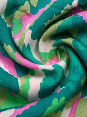 Vibrant V-neck maxi dress fabric with abstract green, pink, and white print.