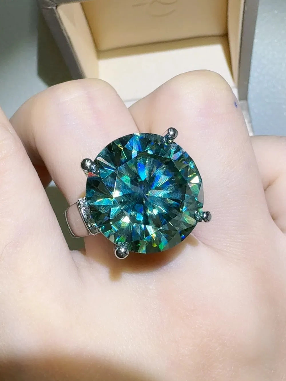 Prismatic teal statement ring with large faceted gemstone and silver band.