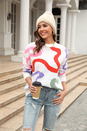 Women's white crewneck sweater with abstract swirl pattern in pink, red, purple, and green.