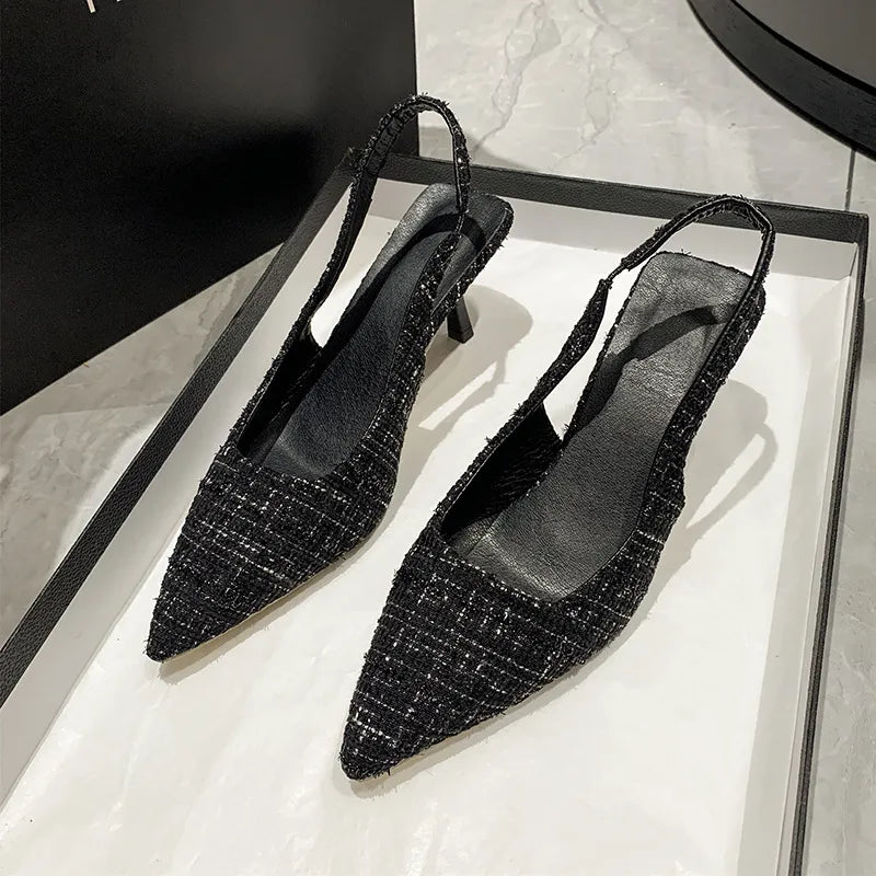 Black tweed slingback kitten heels with pointed toe and elastic strap.