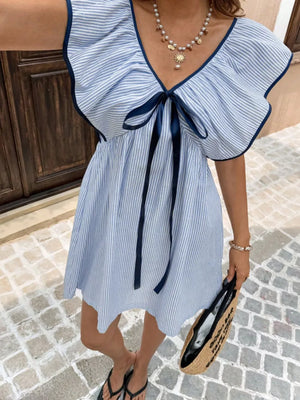 Blue striped mini dress with ruffled sleeves and a navy bow tie detail.