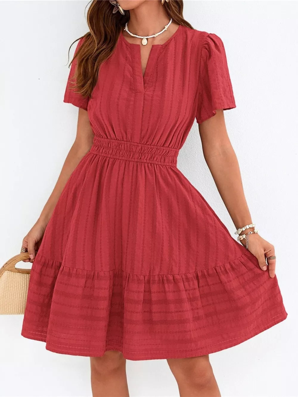 Red textured V-neck tiered dress with smocked waist and short sleeves.
