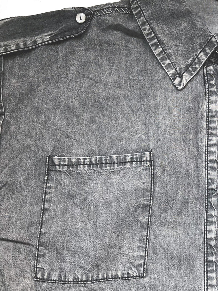 Sleeveless dark gray denim utility shirt with collared neckline and buttoned chest pocket.
