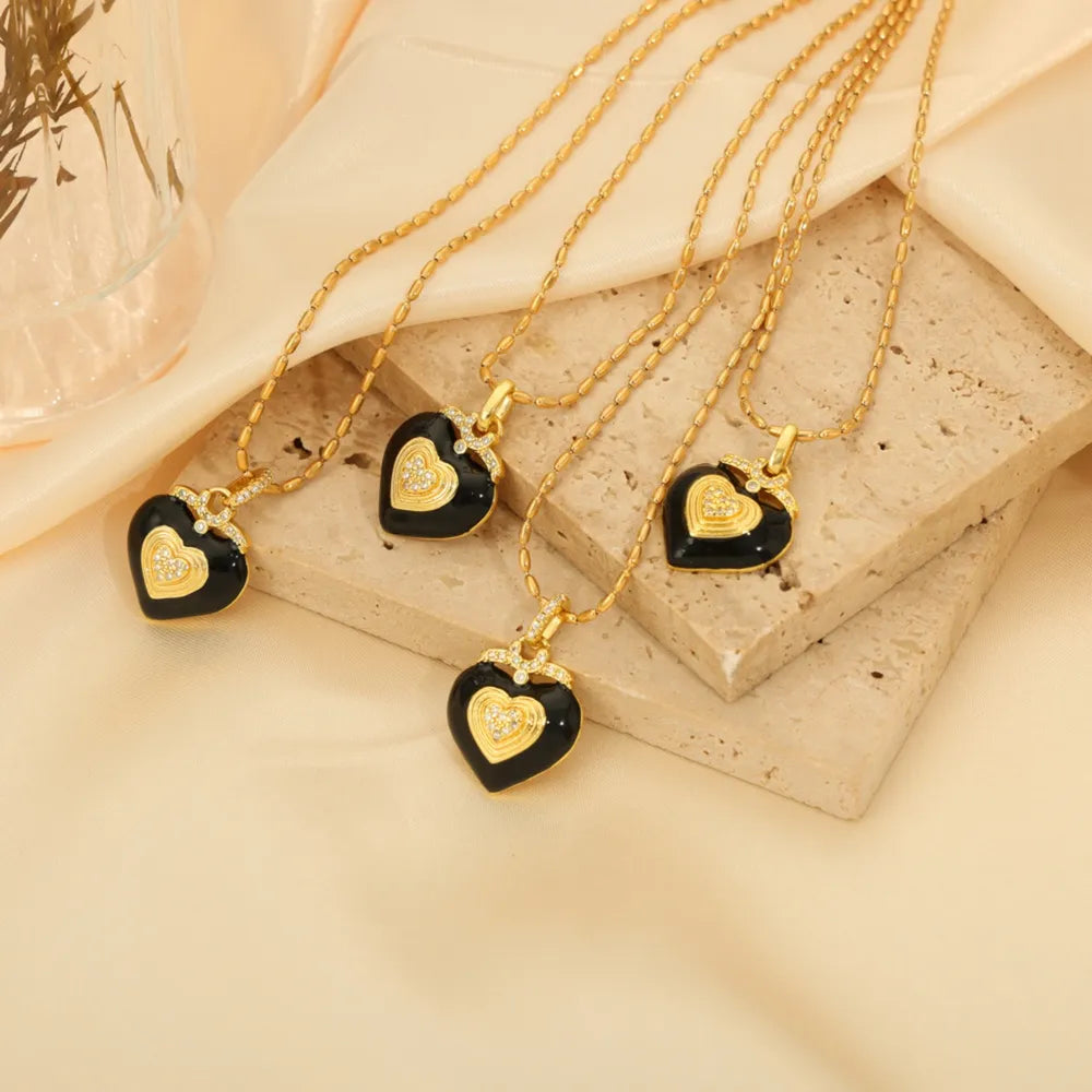 Gold necklace with black enamel heart pendant and diamond accents