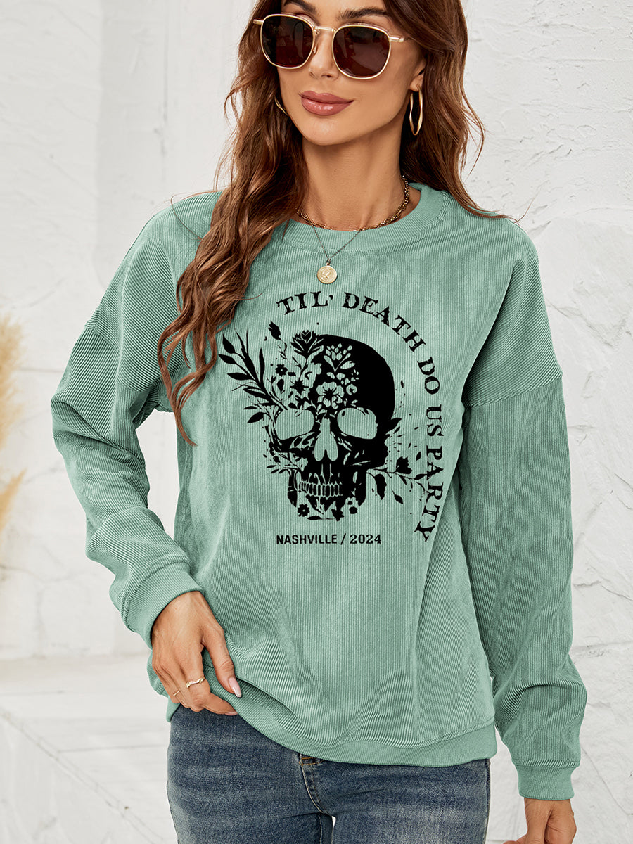 Corduroy sweatshirt in Gum Leaf with a black skull and floral graphic and text.