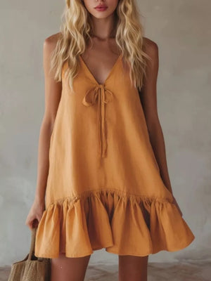 Turmeric tie-front mini dress with V-neck, ruffle hem, and tie detail.