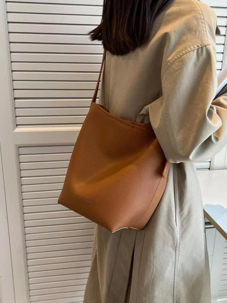 Brown minimalist PU leather shoulder bag with a slouchy silhouette.