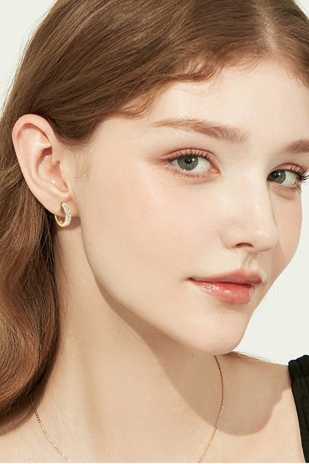 Gold moissanite channel-set hoop earrings with sparkling stones.