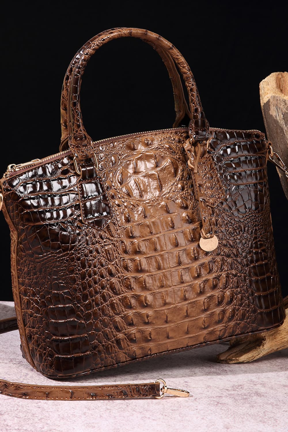 Crocodile embossed satchel bag with top handle in a rich brown hue.