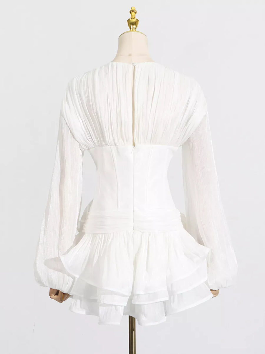 White ruffle mini dress with balloon sleeves and ruched back detail.