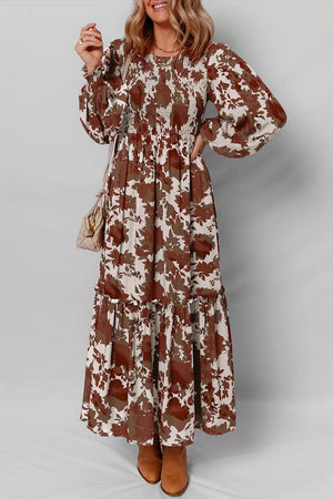 Charming floral maxi dress in beige and brown with smocked bodice and billowy sleeves.