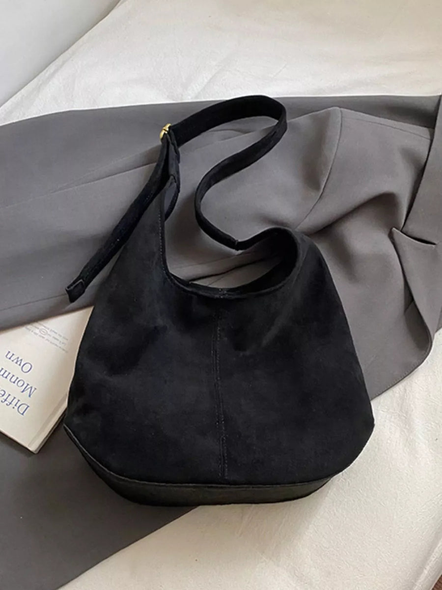 Large black suede hobo shoulder bag with a curved strap and flat base.