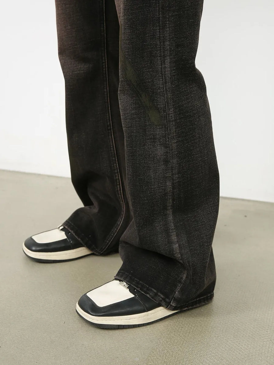 Dark wash denim jeans with a faded, distressed look and a flare cut.