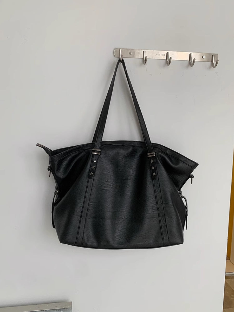 Black pu leather tote bag with star details and double straps.