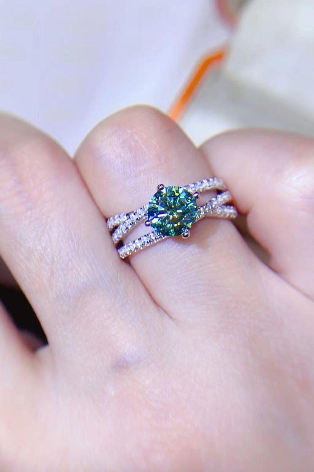 Twisted pavé halo ring with teal stone in 925 sterling silver.