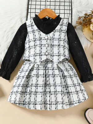 Toddler black long sleeve top with white plaid vest and skirt set with decorative buttons.