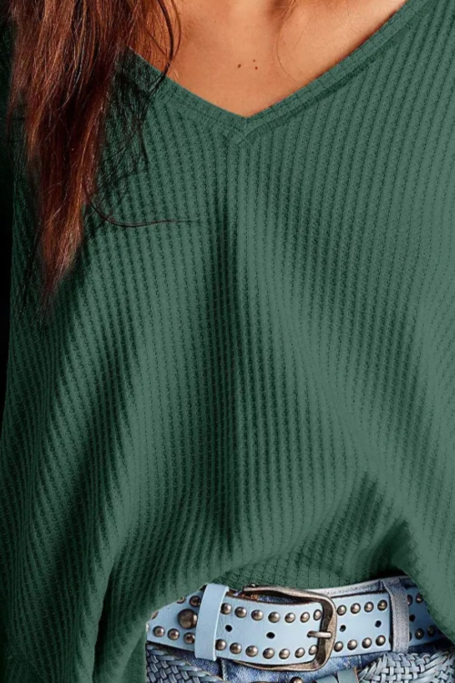 Dark green waffle knit v-neck top with blouson sleeves, shown with a studded belt.