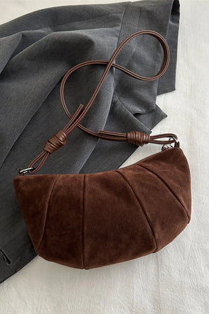 Brown suede crescent shoulder bag with pleated detail and knotted strap