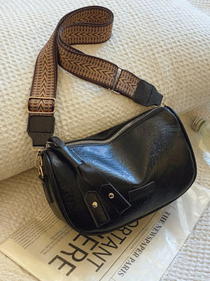 Black crossbody bag with patterned strap and gold hardware