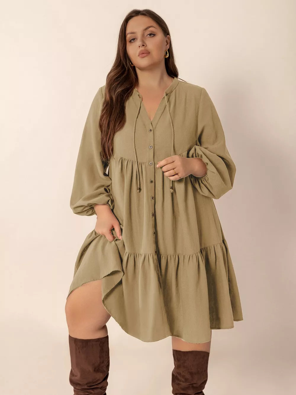 Olive green tie-neck button-front dress with balloon sleeves and tiered skirt.