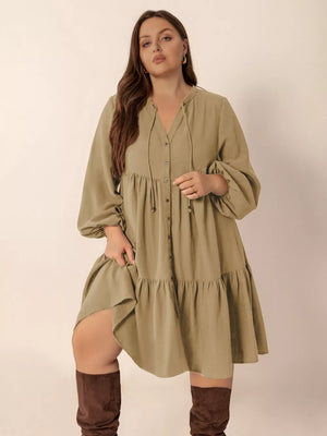 Olive green tie-neck button-front dress with balloon sleeves and tiered skirt.