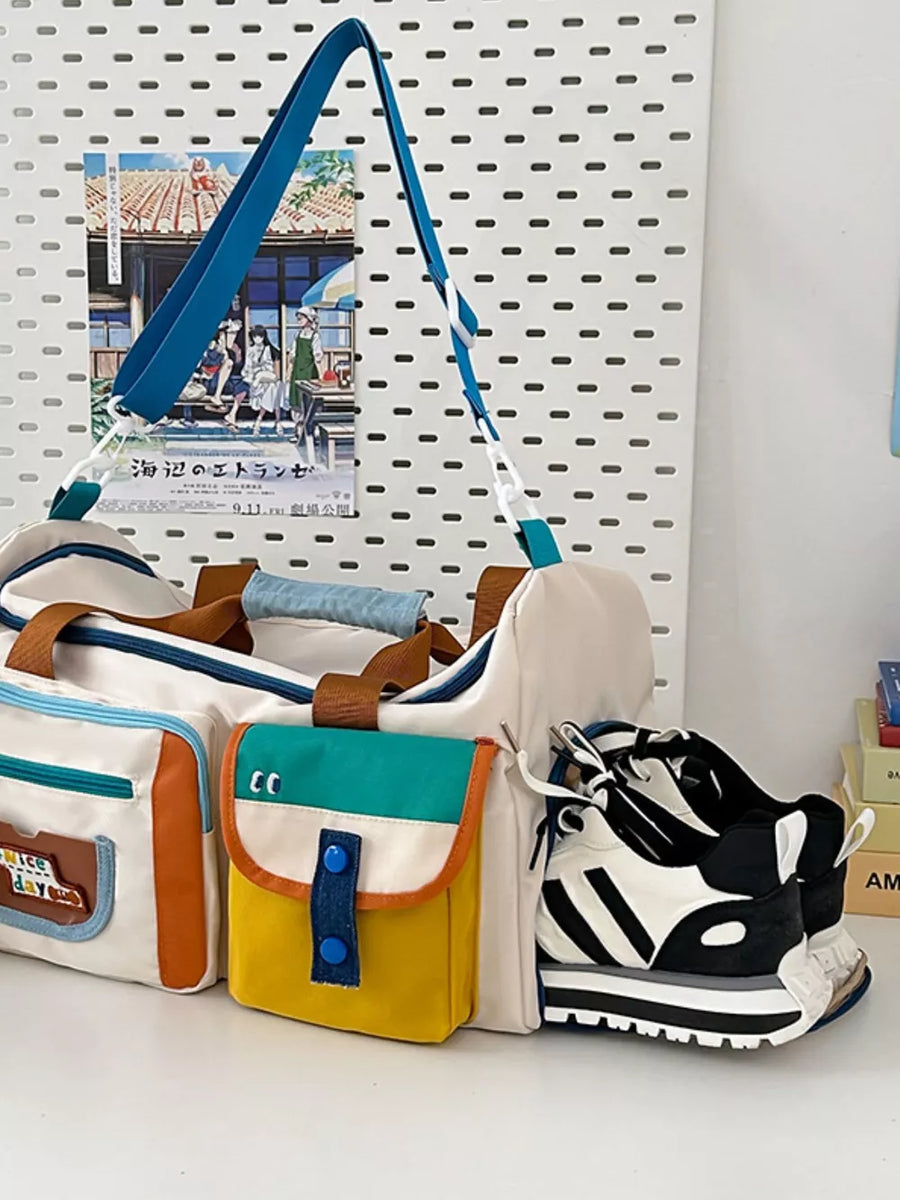 Vibrant multi-pocket nylon travel bag with color block details and a blue strap.