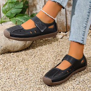 Black round toe platform flats with cutouts and adjustable strap.
