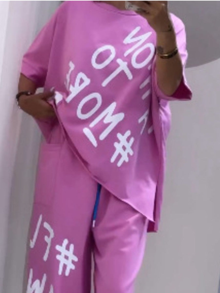 Pink graphic tee and drawstring pants set with white text detail.