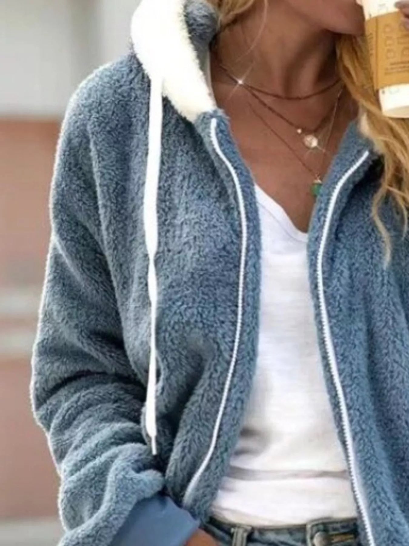 Blue fleece zip-up hoodie with white trim and drawstring, worn over a white tee.