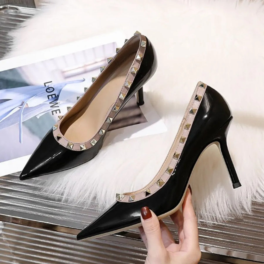 Black patent leather pointed-toe pumps with studded trim