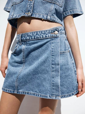 Denim skort with button closure and contrast stitching, part of a cropped top set.