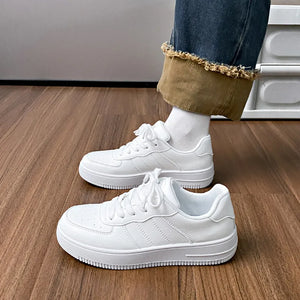 White minimalist platform sneakers with perforations and lace-up closure.