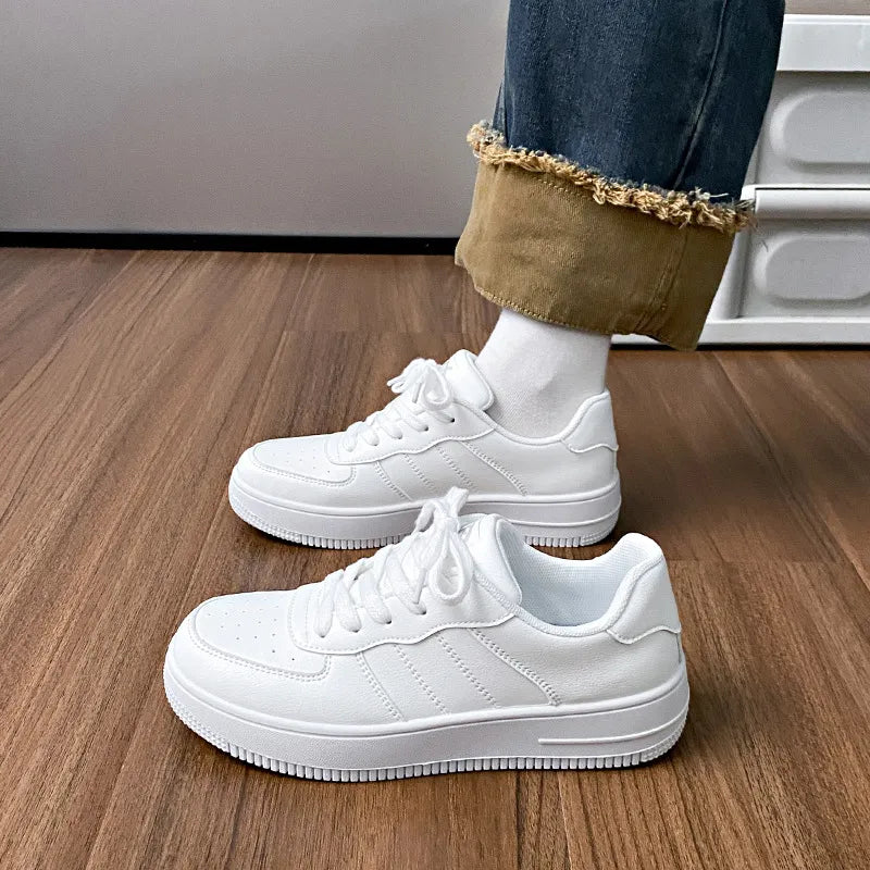 White minimalist platform sneakers with perforations and lace-up closure.