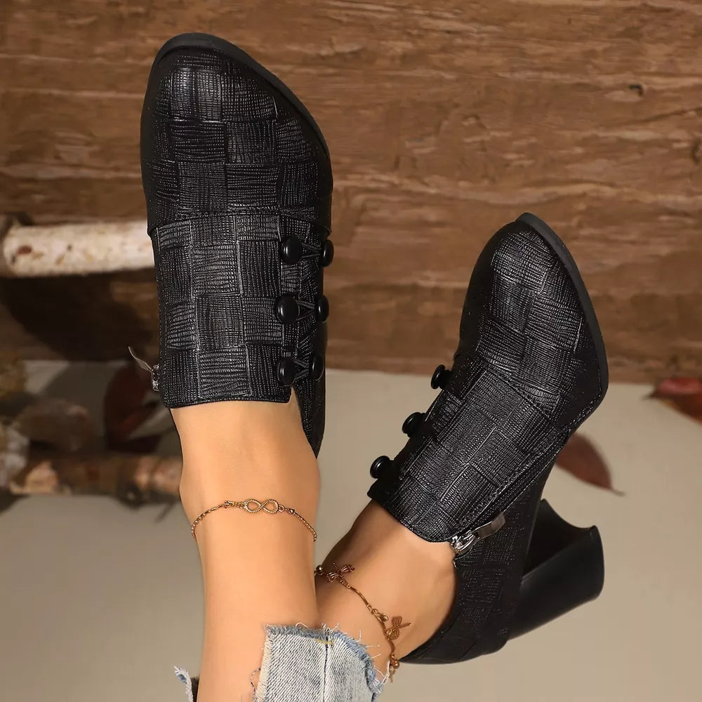 Black woven button-detail high heels with pointed toe and side zipper.